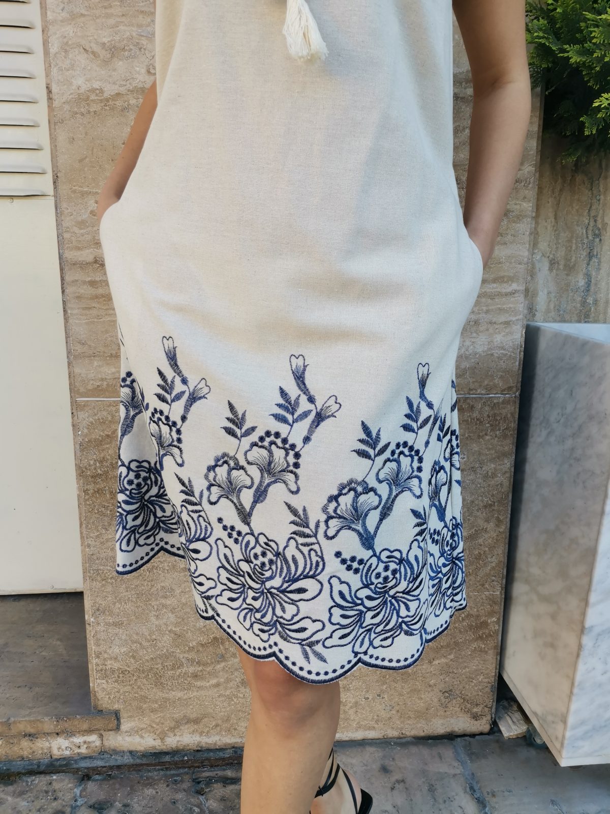 Sleeveless linen dress with blue embroidery on the finish